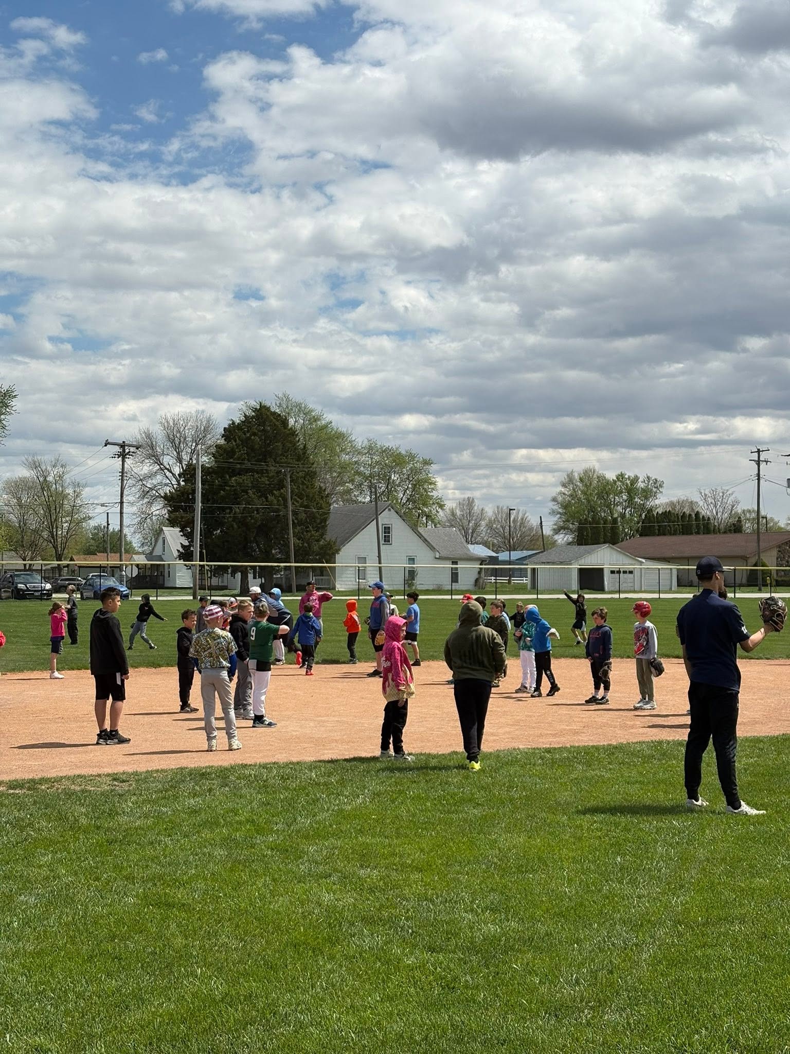 Kids gathered on the infield during a practice session